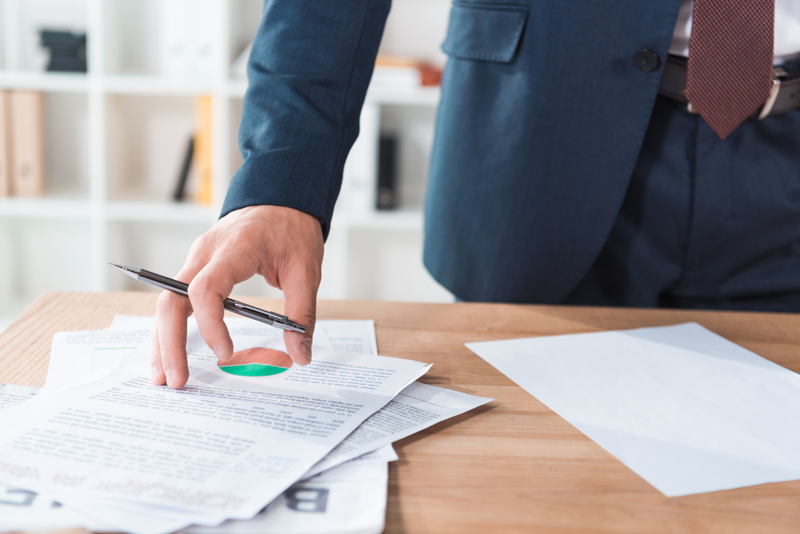etats_financiers-1 a person holding a pen over papers